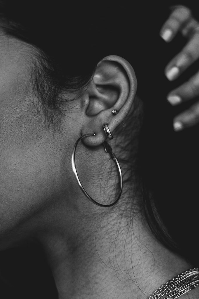 gros plan d'une personne portant une paire de boucles d'oreilles