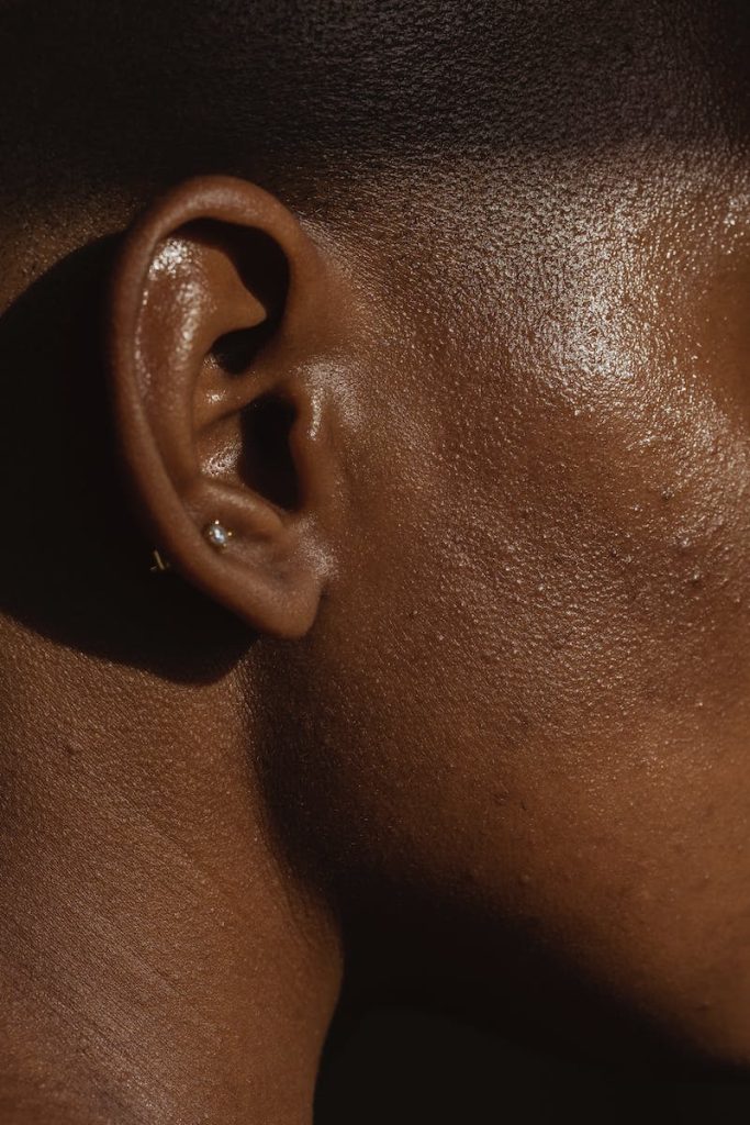 Vue latérale du visage d'une femme anonyme afro-américaine avec un piercing à l'oreille