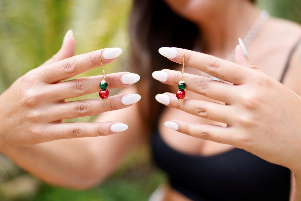 une femme portant un haut noir et tenant une bague rouge et verte